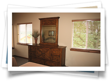 A bedroom with a dresser and a mirror