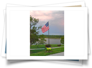 An american flag is flying in front of a lake