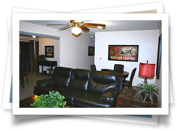 A living room with a black couch and a ceiling fan