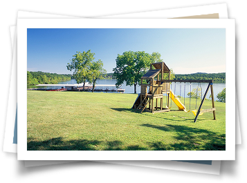 A picture of a playground with a lake in the background