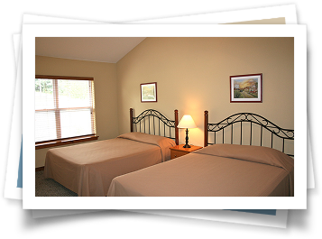 A bedroom with two beds and two pictures on the wall