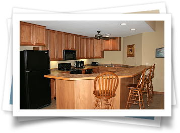 A kitchen with wooden cabinets and a black refrigerator