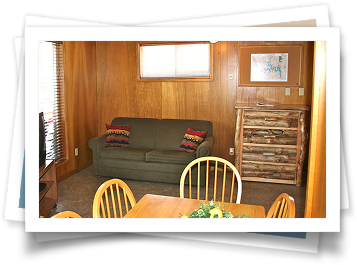 A living room with a couch , table and chairs.