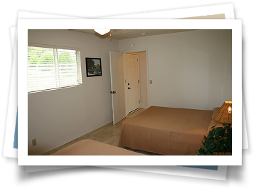 A bedroom with two beds and a picture on the wall