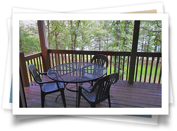 A picture of a deck with a table and chairs on it.