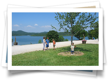 A group of children standing in front of a lake