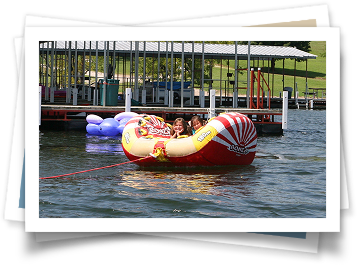 A group of people are riding an inflatable boat on a lake.