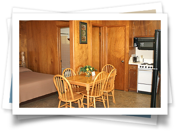 A kitchen with a table and chairs and a refrigerator