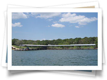 A picture of a lake with a dock and trees in the background