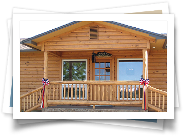 A picture of a log cabin with a porch