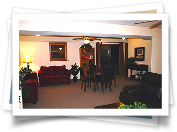 A living room with a red couch and black chairs