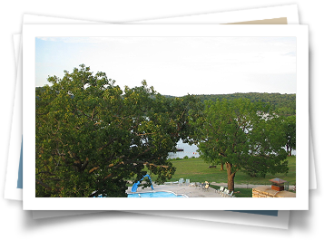 A picture of a swimming pool with a lake in the background