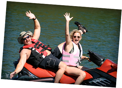 A man and a woman are riding a jet ski in the water