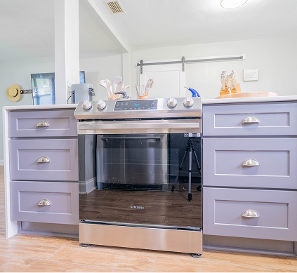 A kitchen with stainless steel appliances and purple cabinets