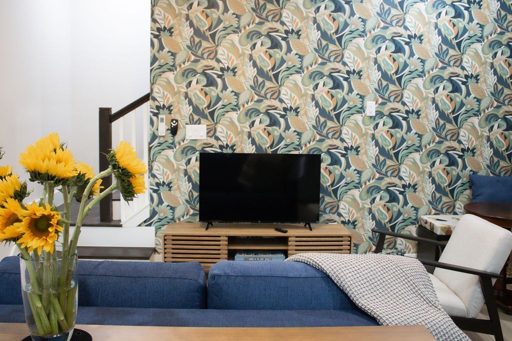 A blue house with a green house in the background