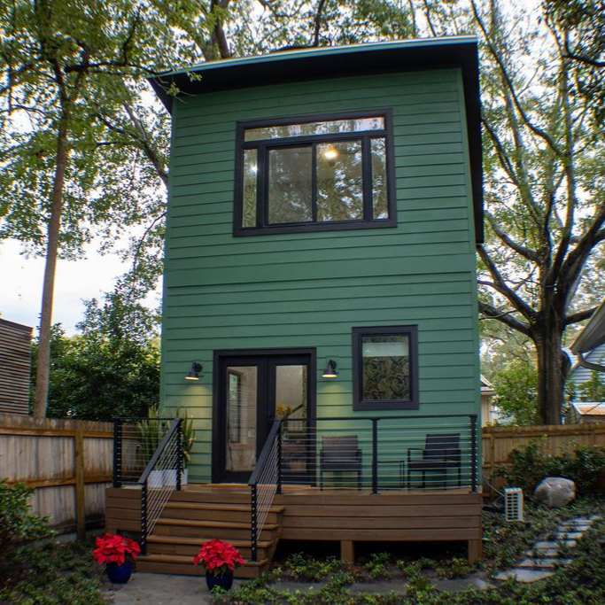 A house with a large window and stairs leading up to it.