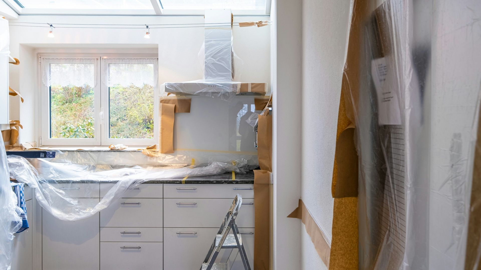 a kitchen is being remodeled and covered in plastic wrap .