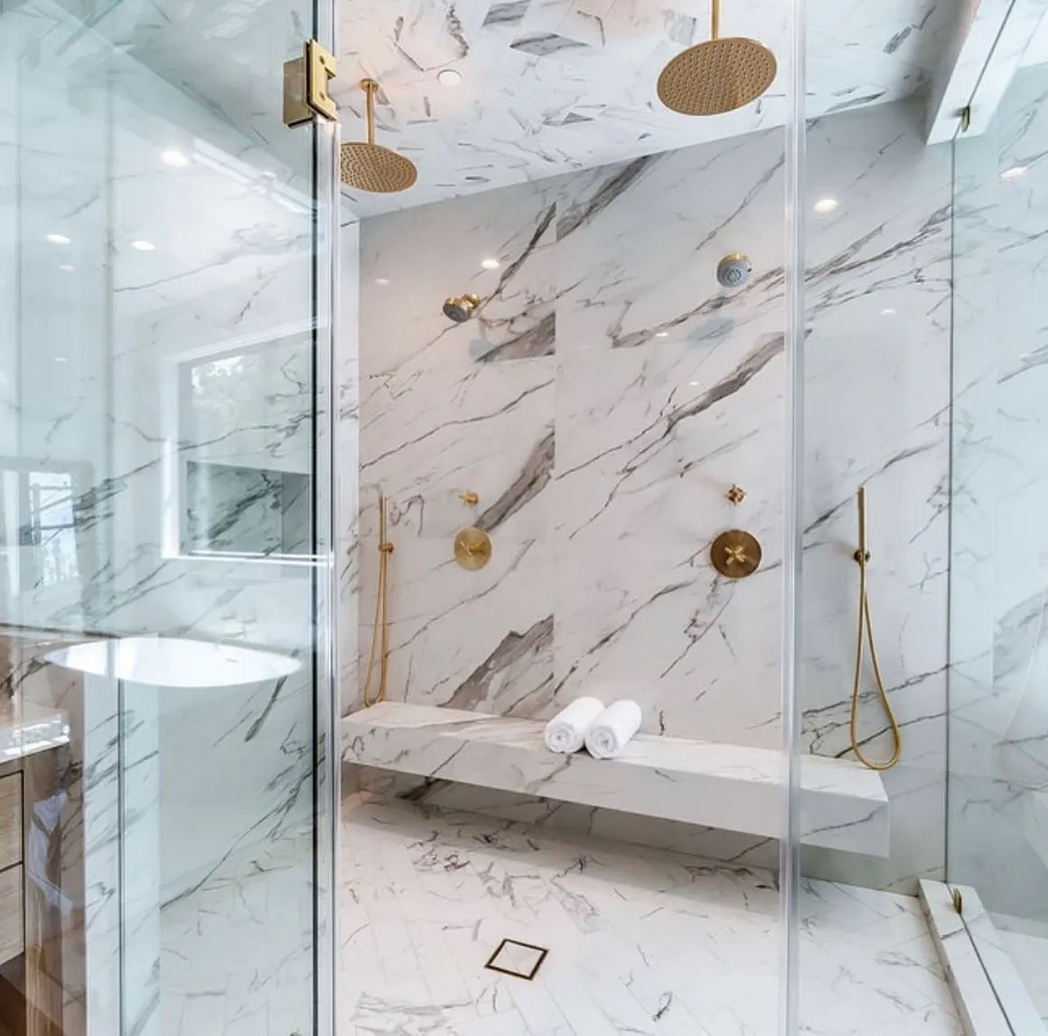 a bathroom with marble walls and a walk in shower