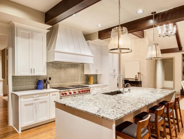 a kitchen with white cabinets and granite counter tops