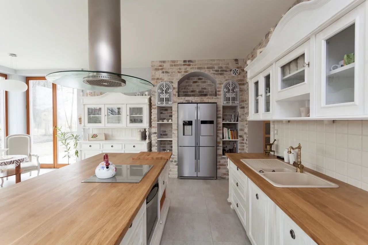 a kitchen with white cabinets and a stainless steel refrigerator