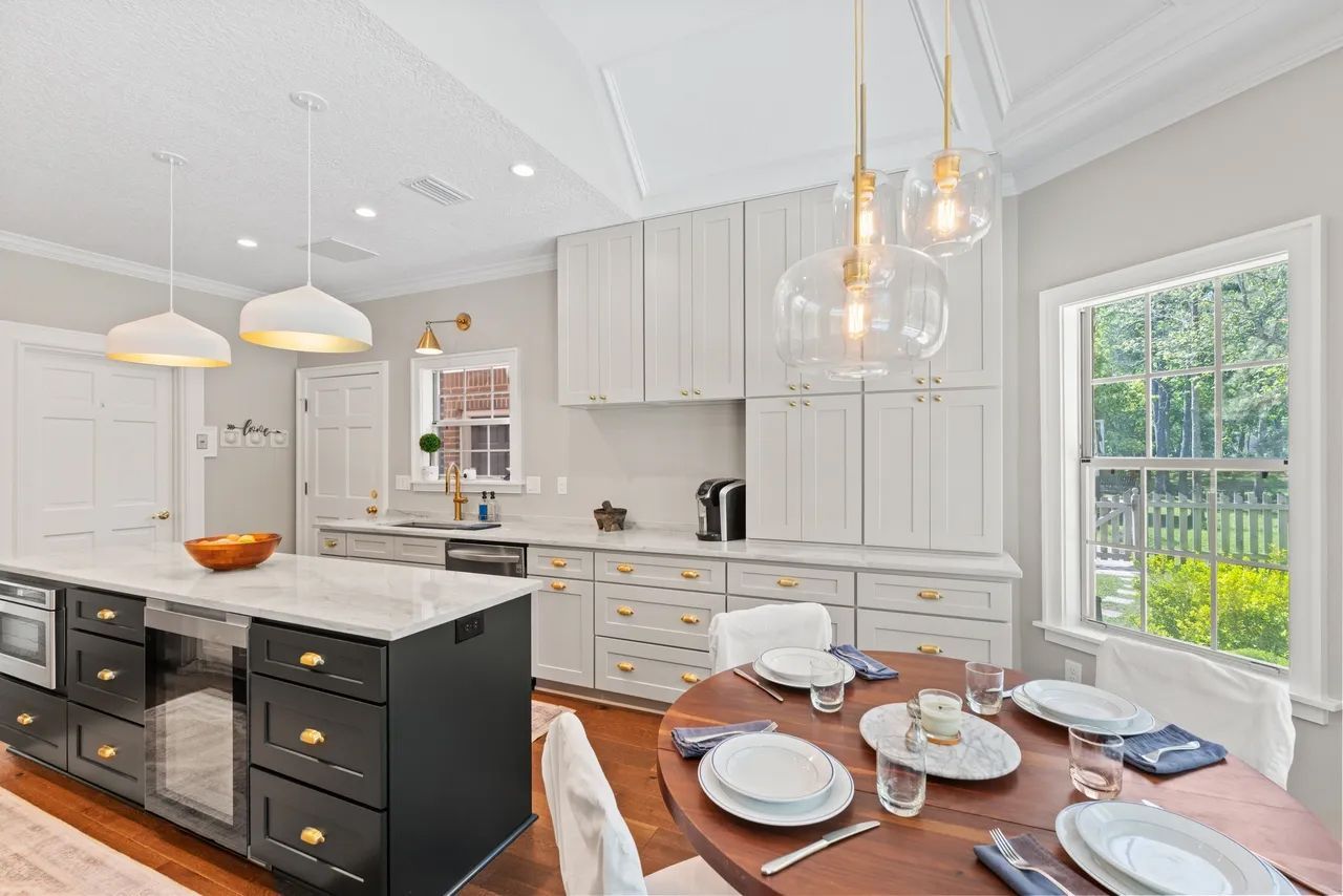 a kitchen with white cabinets and a black island