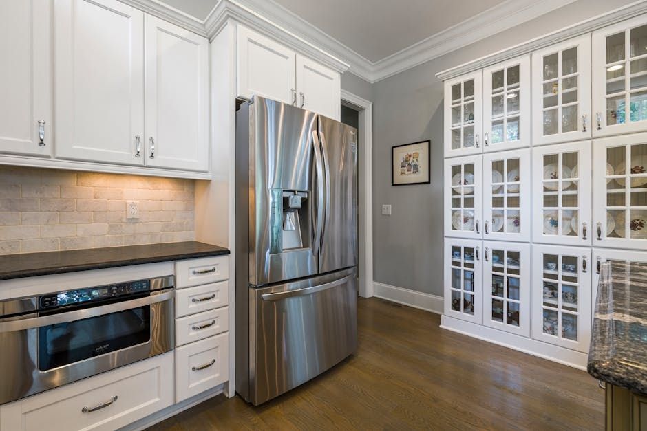 White kitchen cabinets and stainless steel refrigerator.