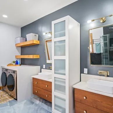 a bathroom with a washer and dryer, sink, mirror and shelves .