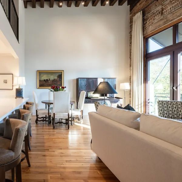 a living room with a white couch, dining table and chairs