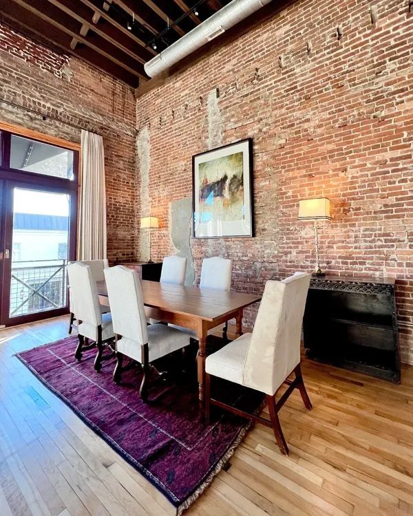 a dining room with a table and chairs and a brick wall