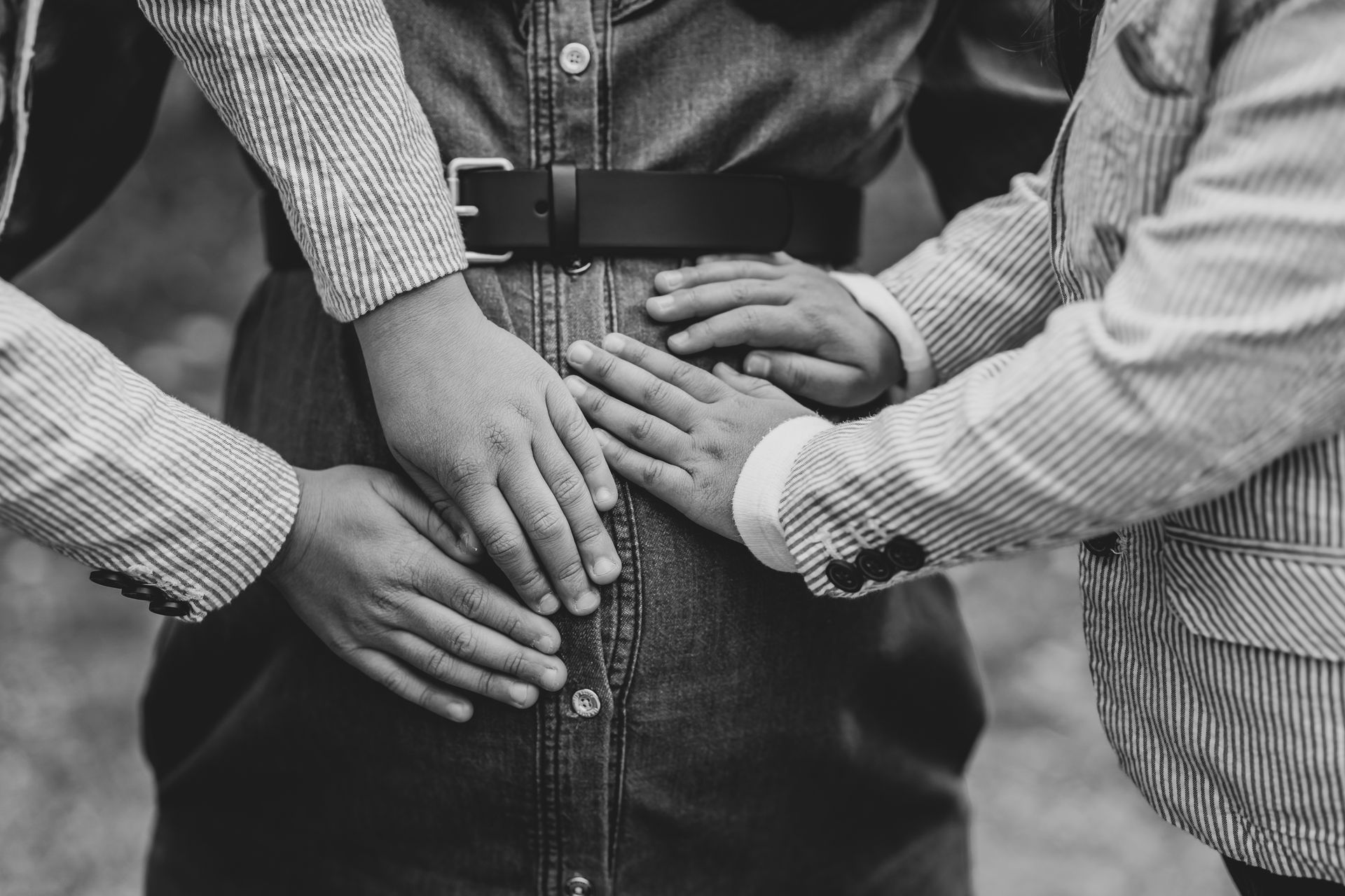 pregnant lady with two children having their hands on tummy