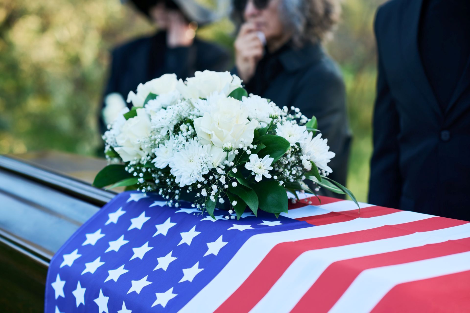 A man in a military uniform salutes in front of a cemetery