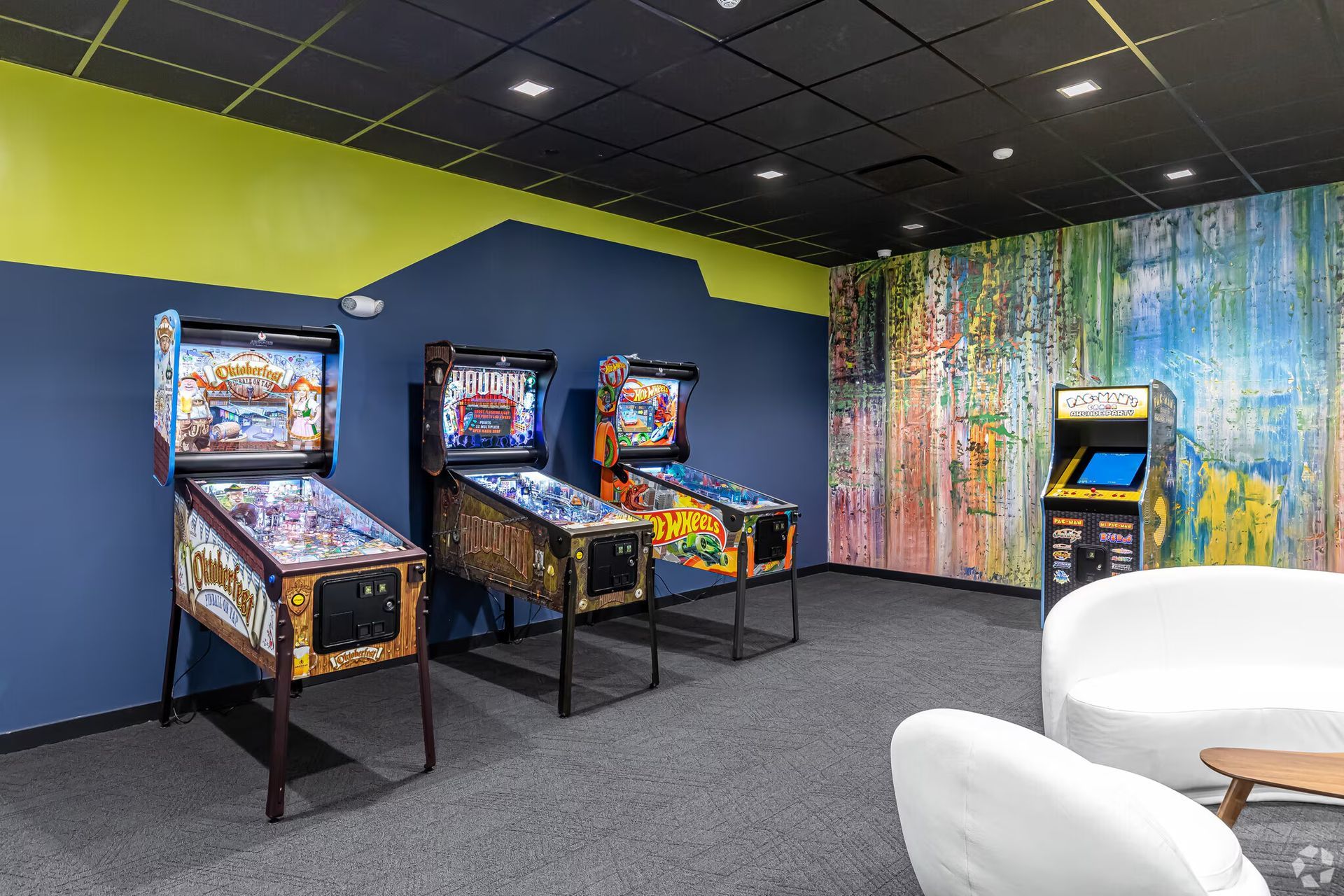 Arcade-style game room with pinball machines at The Millennium luxury apartments