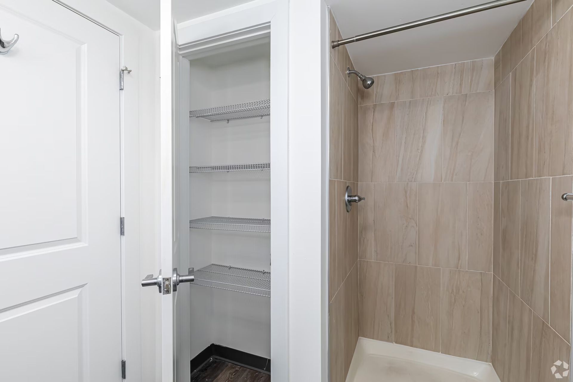 Bathroom storage closet and tiled shower at The Millennium apartments