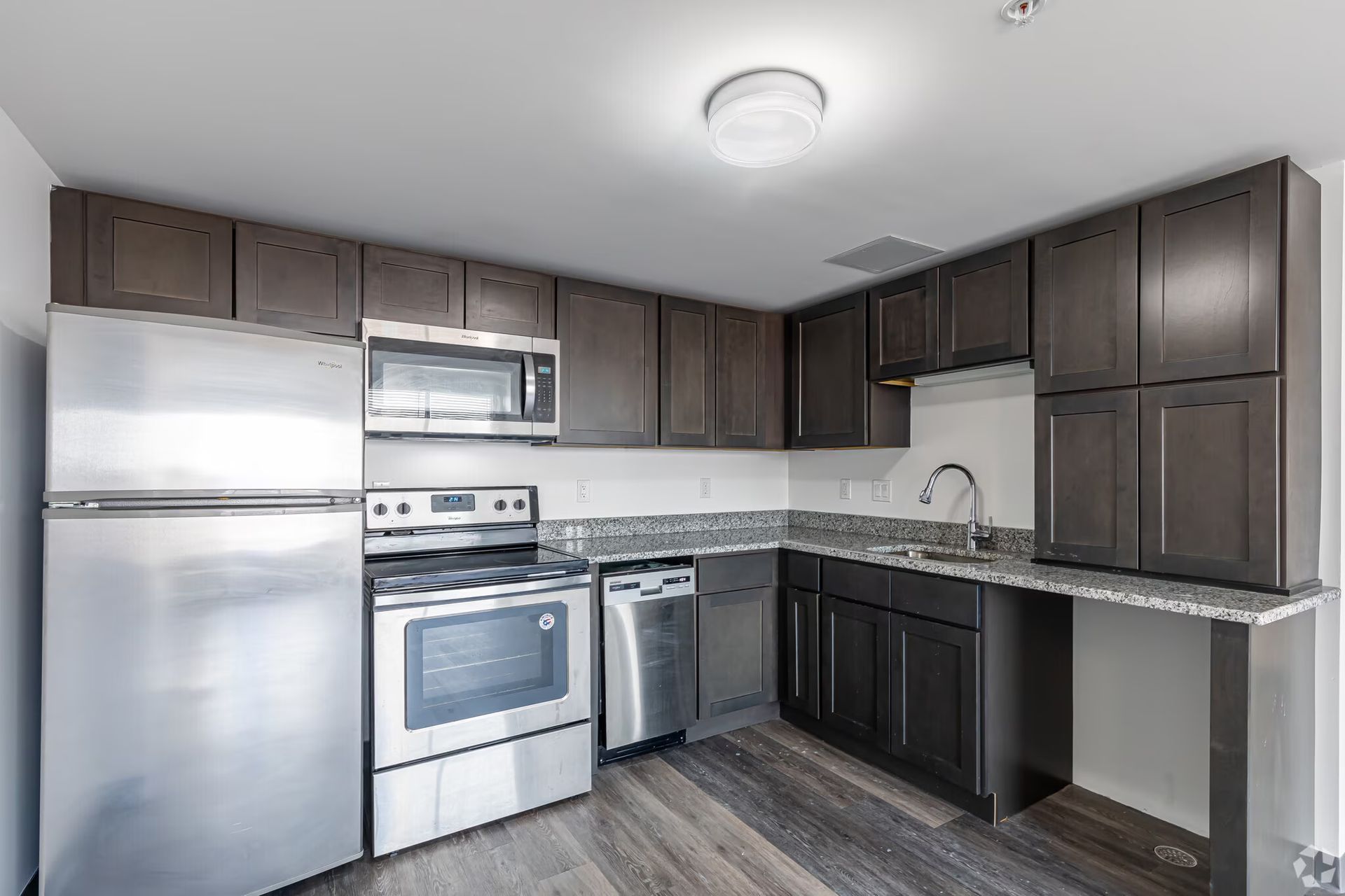 Contemporary apartment kitchen with granite countertops at The Millennium apartments