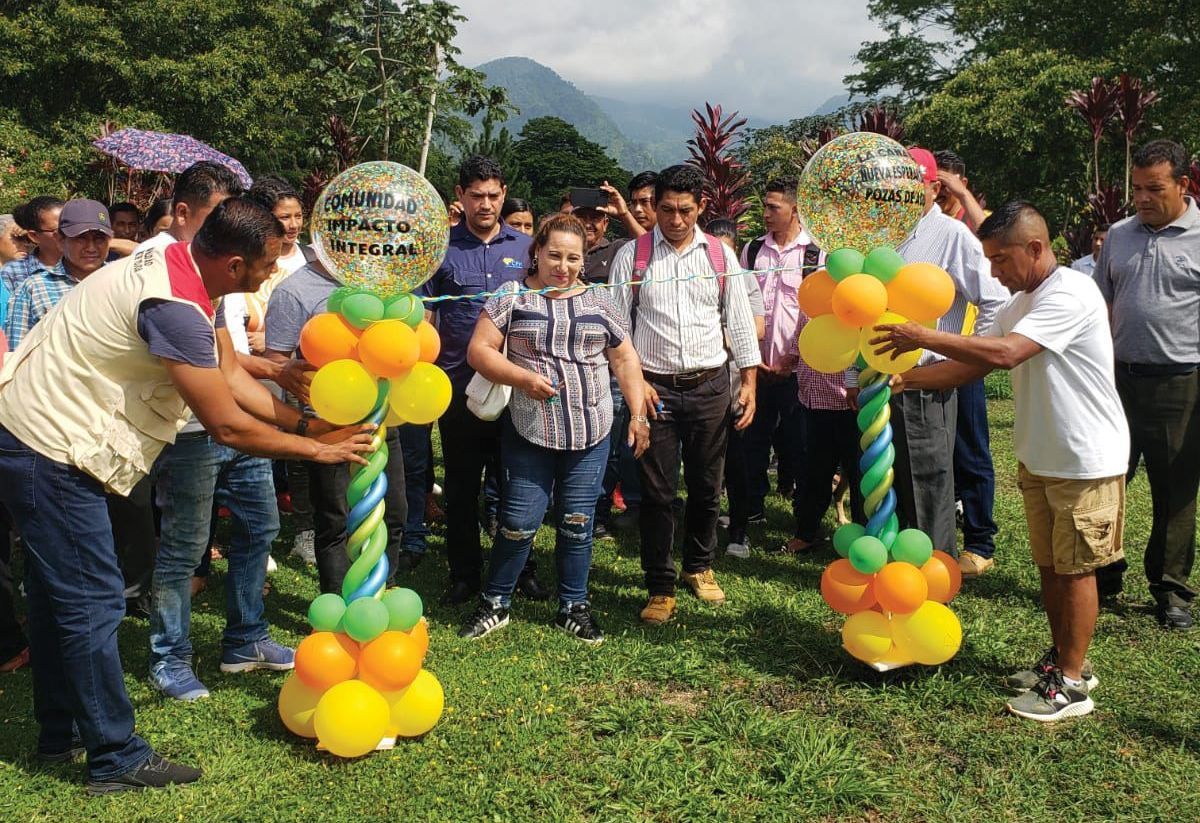 Celebrating the opening of a new cohort, a crowd of people gather to cut a ribbon in Santa Elena.