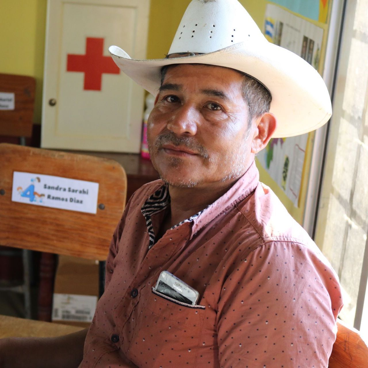 A team member in a cowboy hat gives a half-smile to the camera.