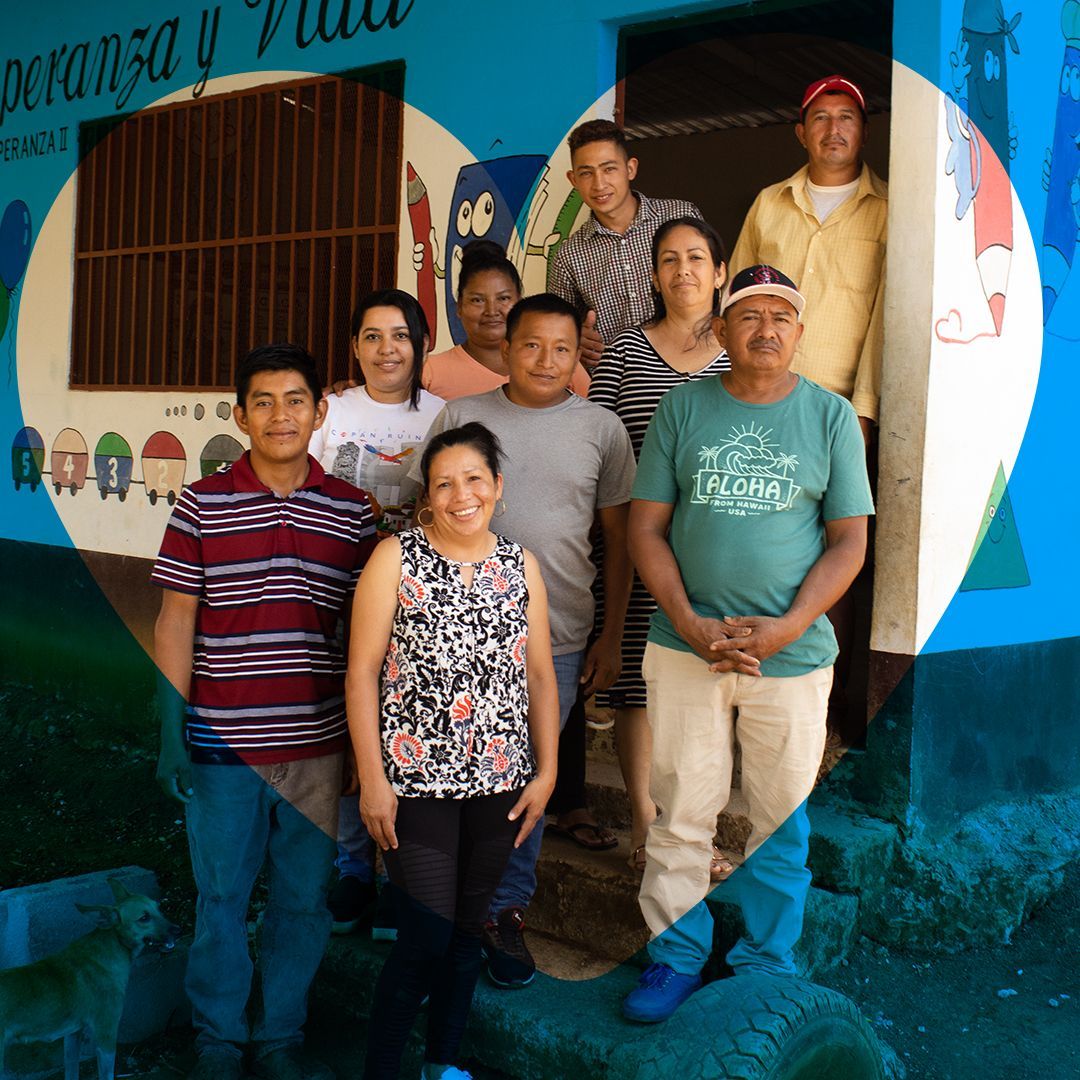 Team members pose in front of a Honduran school.