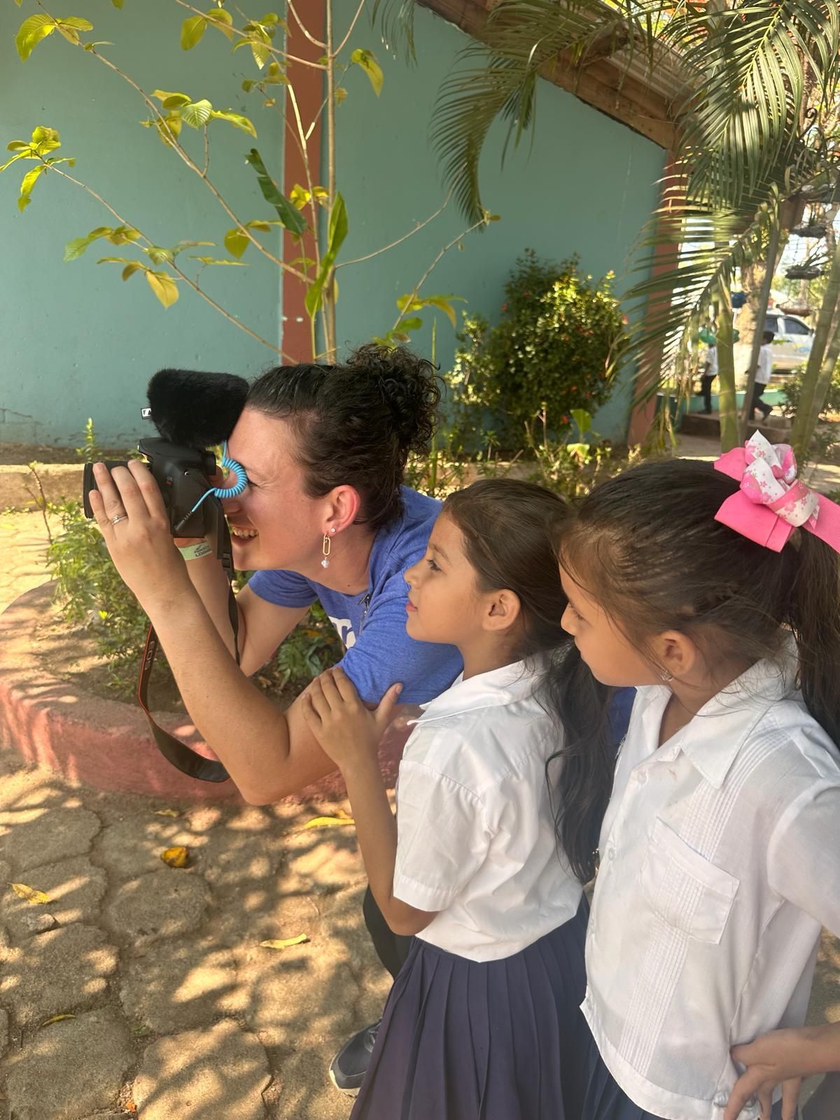 A team member takes photos while two little girls watch on with interest.