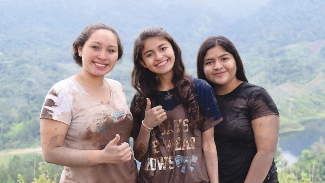 Three youth girls from CEI smiling at the camera.