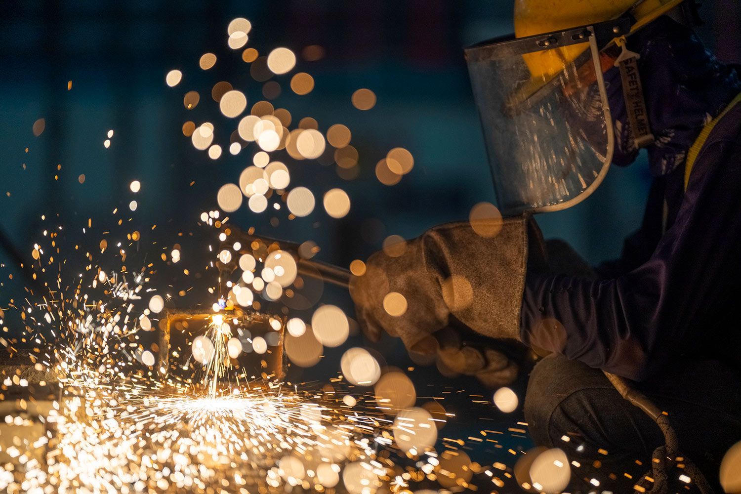 Skilled worker performing welding services with gas cutting torch on steel in workshop, precision metalwork, industrial safety | Spradlin Bros Welding Co.