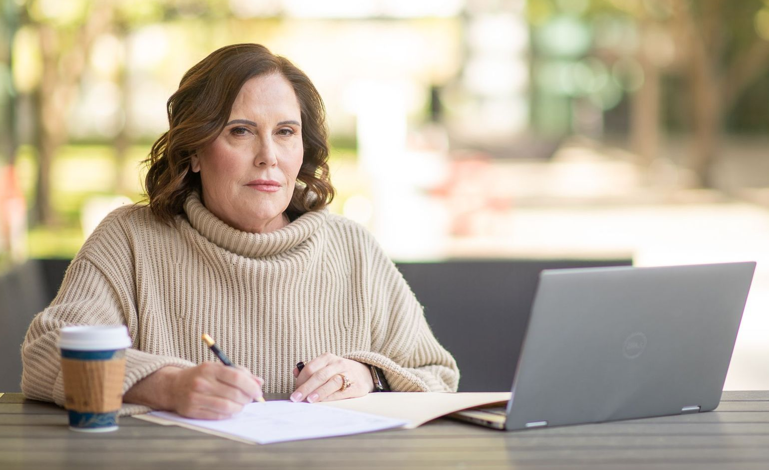 Sheila Wysocki working at a desk in an outdoor cafe
