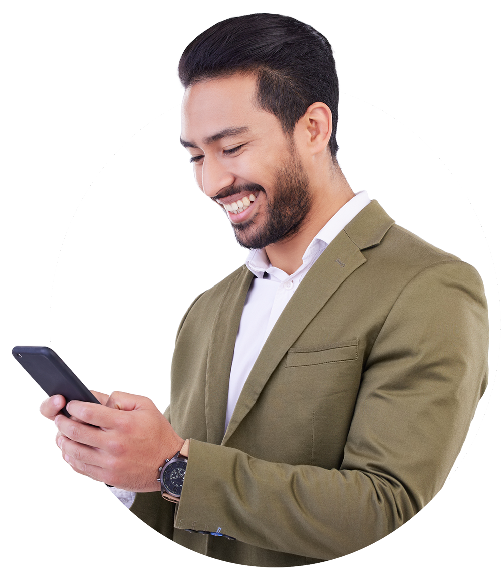Smiling man in a blazer looks at his phone. He has dark hair and a beard.
