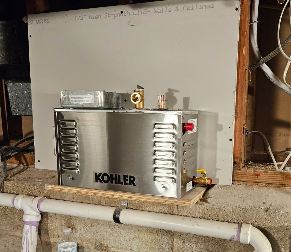 A large, dark-bladed industrial steam turbine rotor rests on metal stands inside a power plant maintenance area.