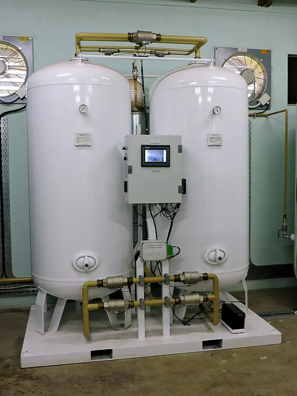 A furnace and water heater with metal ventilation pipes in a basement with concrete walls and floors.