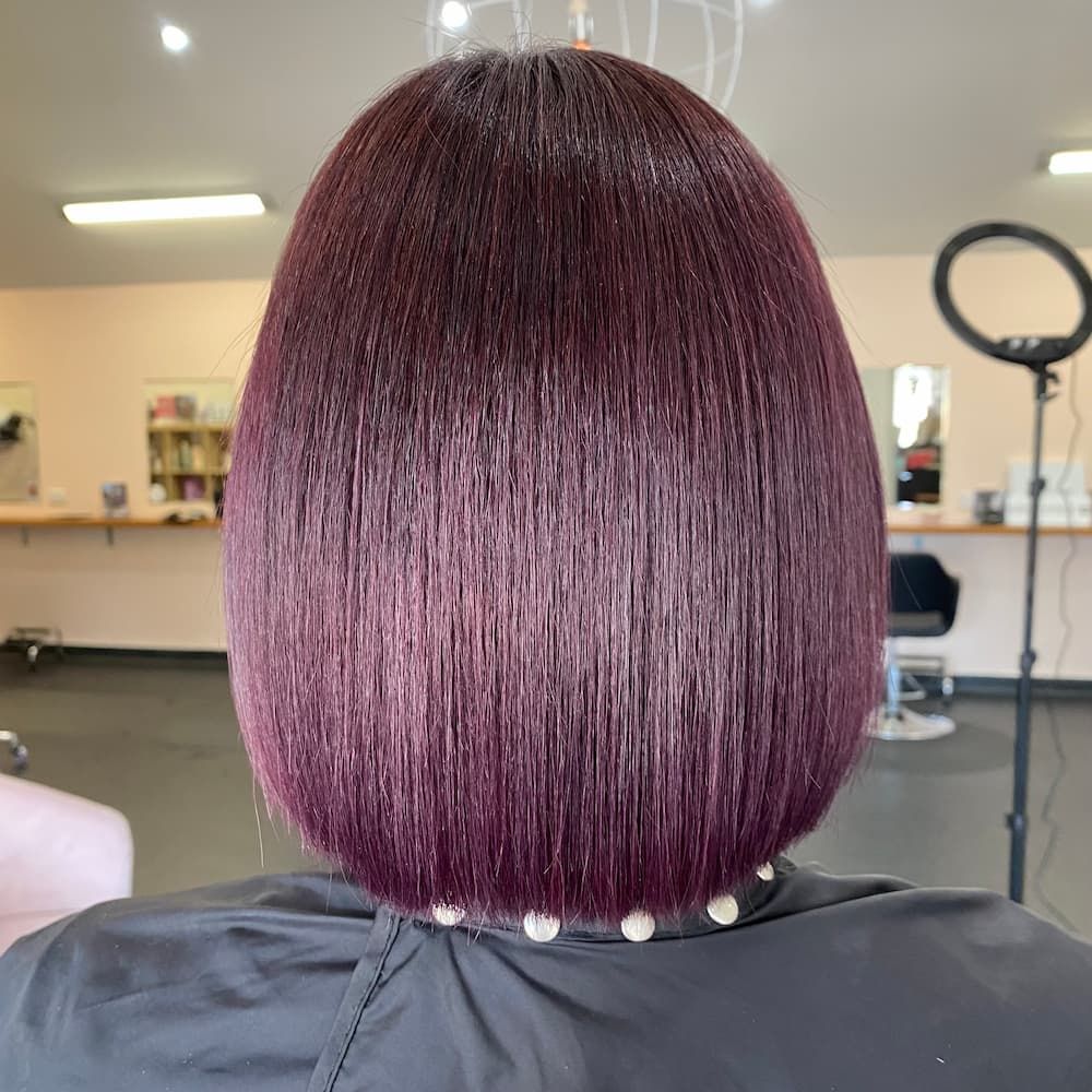 A Woman With Purple Hair Is Getting Her Hair Cut In A Salon — Haelo Hair In Bomaderry, NSW