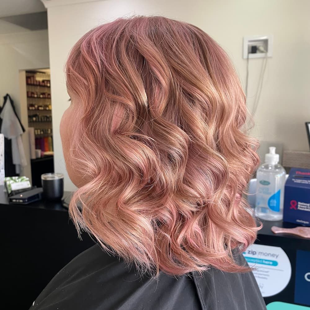 A Woman With Pink Hair Is Getting Her Hair Cut In A Salon — Haelo Hair In Bomaderry, NSW