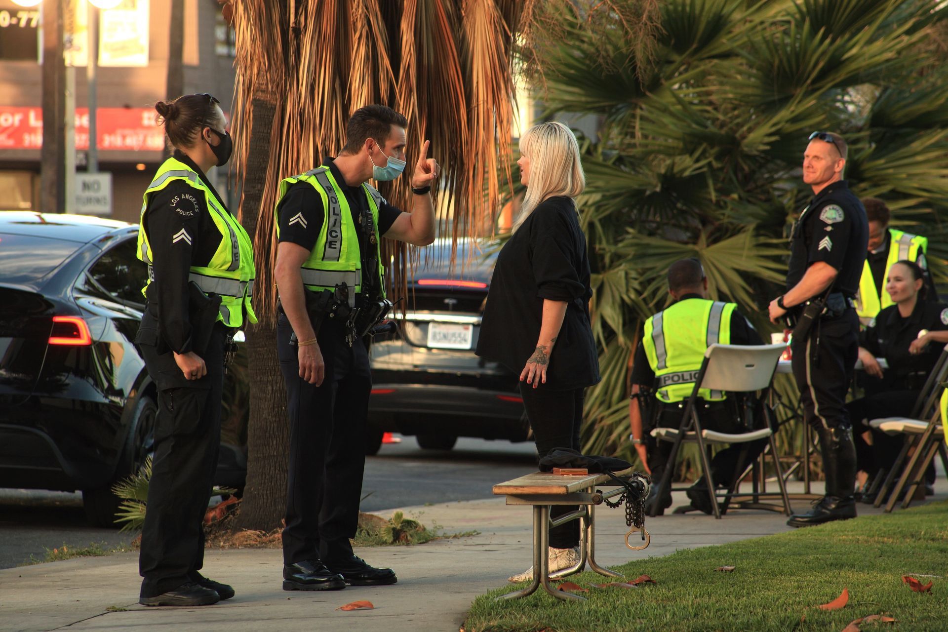 A group of police officers talking to a woman.