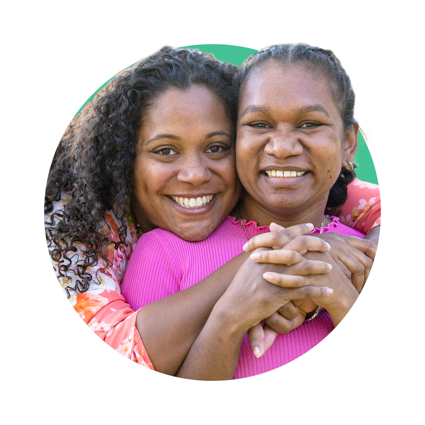 First Nations' mother embracing her daughter and both smiling and facing towards the camera