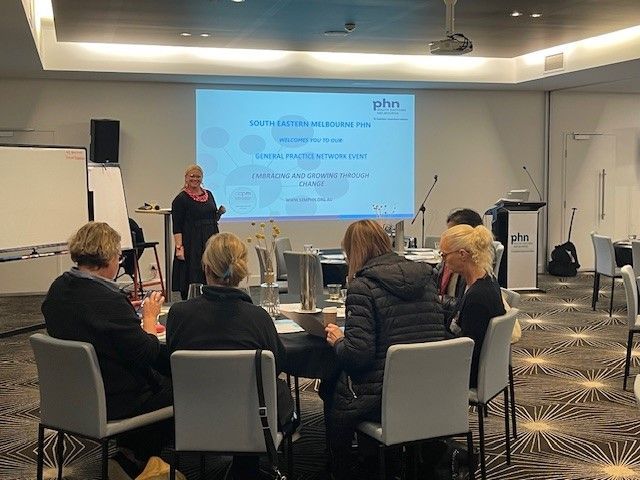 A woman is giving a presentation to a group of people in a conference room.