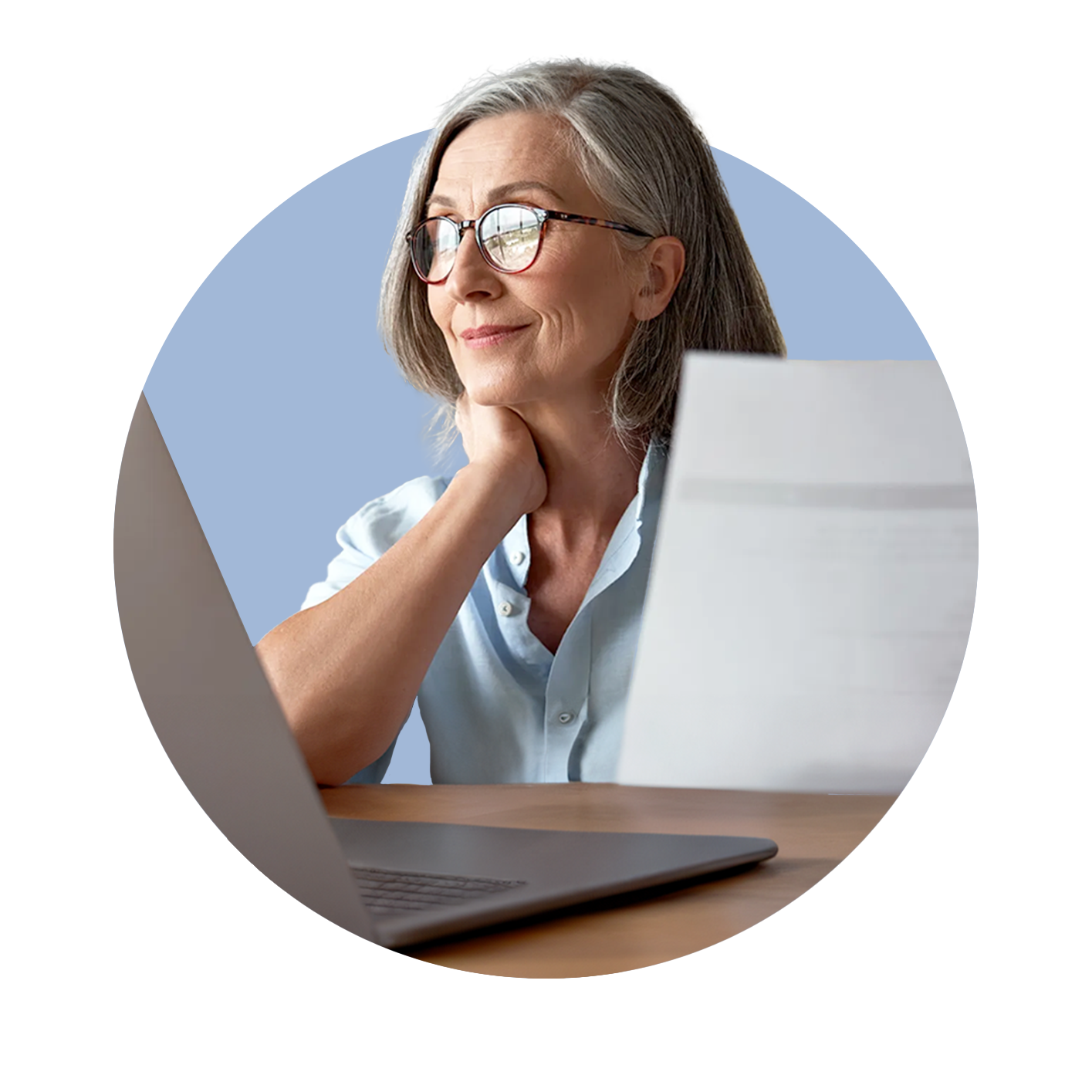 Professional woman holding paper and with laptop in front of her, facing towards a window